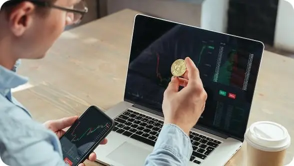 Analiza rynku kryptowalut na laptopie i smartfonie podczas handlu z Immediate Profit